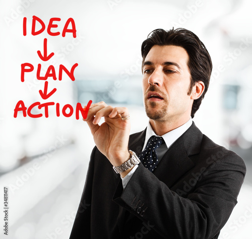 Photo: Businessman writing an action plan Businessman writing an action plan