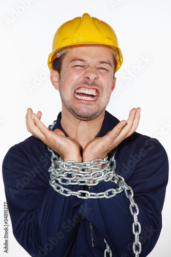 Photo: Man trying to break away from being chained Man trying to break away from being chained
