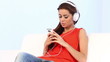 Young girl on couch listen to the music with headphones