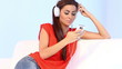 Cute girl on couch listen to the music with headphones
