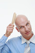 Bald man combing his head