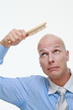 Bald man combing his head