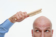 Bald man combing his head