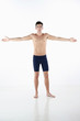 Shirtless man in tights with his arms outstretched