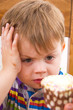 Young boy contemplating cupcake