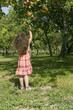 Jeune fille attrapant une pomme dans un arbre