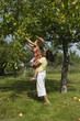 2 jeunes filles s'entraidant pour cueillir des pommes