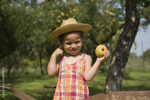 Photo: Portrait d'une jeune fille tenant une pomme Portrait d'une jeune fille tenant une pomme