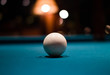 A single white billard ball against a billard table
