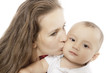 Happy mom kisses her little baby