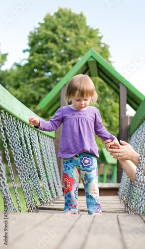 Foto: Young baby girl in the playground. Young baby girl in the playground.