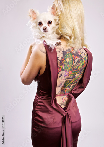 Photo: Blond beauty with her little dog and tattoo on her back Blond beauty with her little dog and tattoo on her back