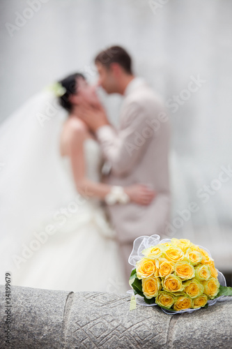 Photo: Wedding bouquet with the wedding couple in the background Wedding bouquet with the wedding couple in the background