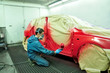 Painting a red car.