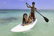 young couple with their paddle board in hawaii young couple with their paddle board in hawaii
