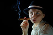 Photo: Woman in black hat with smoking cigar black background isolated Woman in black hat with smoking cigar black background isolated