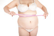 fat  woman in white underwear measuring her stomach