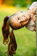 portrait of little pretty girl playing at summer green park