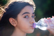 bambina beve acqua dalla bottiglia