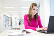 in the library - pretty, female student with laptop and books