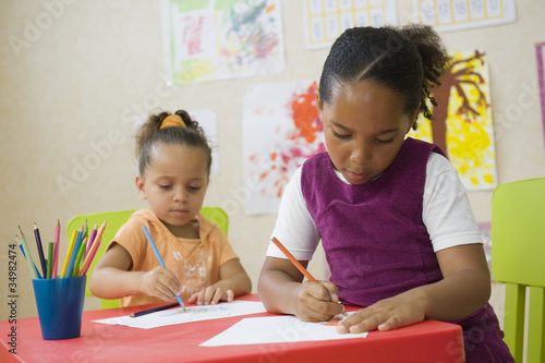 Photo: Jeunes enfants en classe de maternelle dessinant Jeunes enfants en classe de maternelle dessinant
