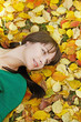beautiful girl  resting on yellow autumn leaves