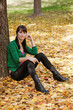 beautiful girl with dark hair resting in autumn park