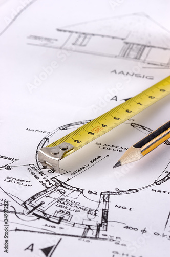 Photo: Measuring tape and pencil on a technical drawing Measuring tape and pencil on a technical drawing