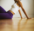 Hispanic woman in sportswear sitting on floor