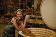 Woman with clay sculpture near kiln