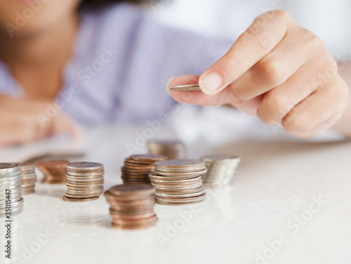 Photo: Hispanic girl stacking coins Hispanic girl stacking coins