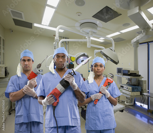 Foto: Surgeons holding tools in operating room Surgeons holding tools in operating room
