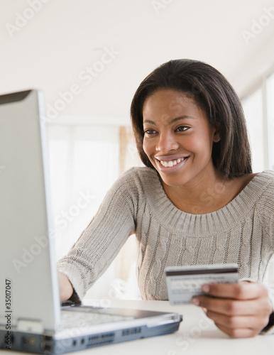 Photo: Mixed race woman shopping online with credit card Mixed race woman shopping online with credit card