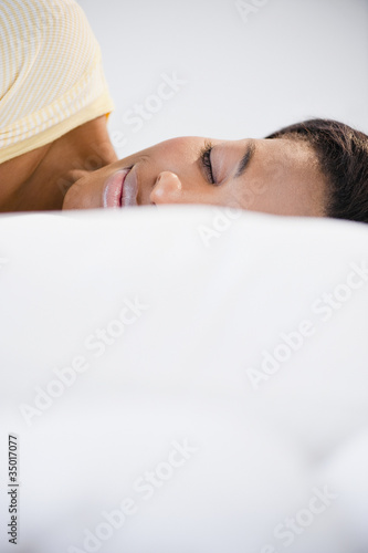 Photo: Mixed race woman sleeping in bed Mixed race woman sleeping in bed