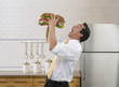 Pacific Islander businessman eating large sandwich