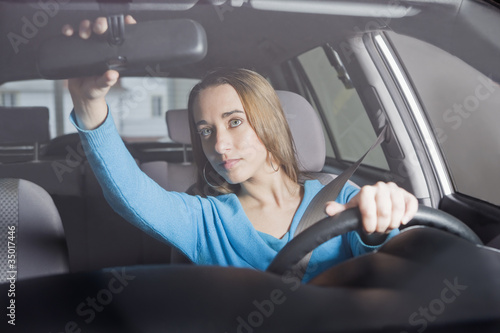 Photo: Hispanic woman adjusting rearview mirror Hispanic woman adjusting rearview mirror