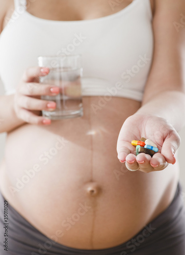 Photo: Pregnant Hispanic woman with handful of pills Pregnant Hispanic woman with handful of pills