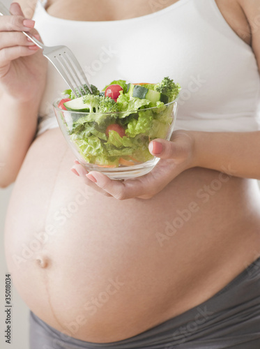 Photo: Pregnant Hispanic woman eating salad Pregnant Hispanic woman eating salad