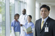 Chinese businessman in hospital with doctors and nurses