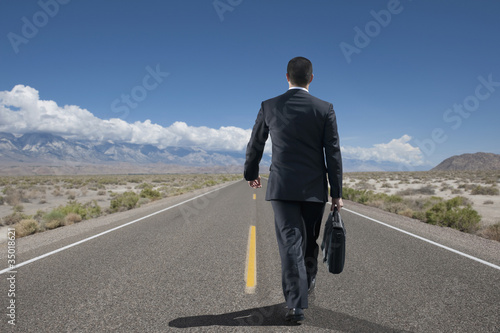 Photo: Asian businessman talking on remote highway Asian businessman talking on remote highway