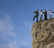 Photo: Business people in blindfolds walking off cliff Business people in blindfolds walking off cliff