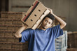 Mixed race man carrying cardboard box in warehouse