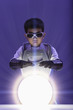 Korean boy in superhero costume looking at glowing orb