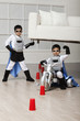 Korean superhero boy lifting sofa for brother to ride underneath