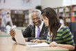 Librarian helping student do research in school library