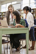 Librarian helping students with research in school library