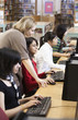 Librarian helping students with research in school library