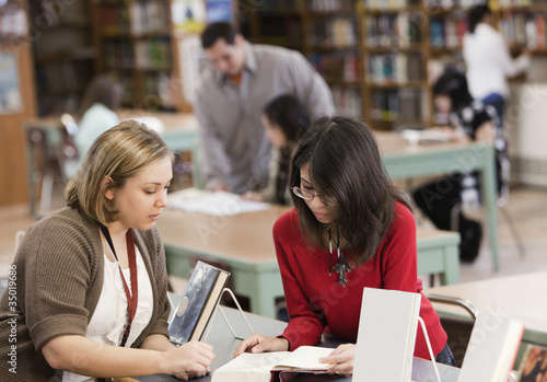 Photo: Student talking to librarian in school library Student talking to librarian in school library