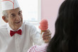 Senior Hispanic man serving ice cream to customer