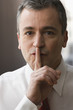 Caucasian businessman making shhh gesture